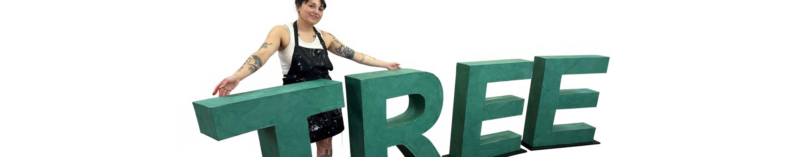 Large green cardboard letters displayed with their maker