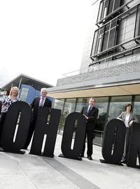 People standing with large black event letters