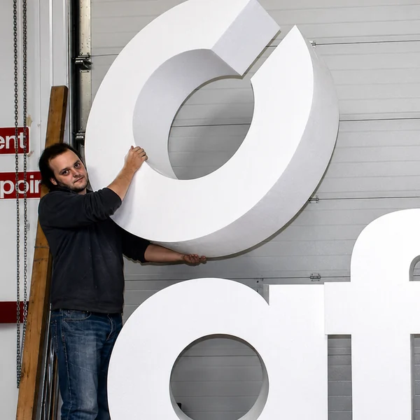 Workshop team member holding large white polystyrene letters