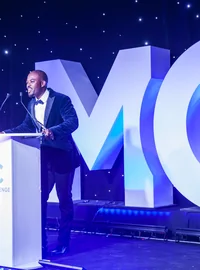 Speaker on stage beside oversized MC event letters