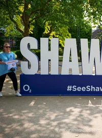 Large white See Shawn Live event letters with a visitor posing for a photograph