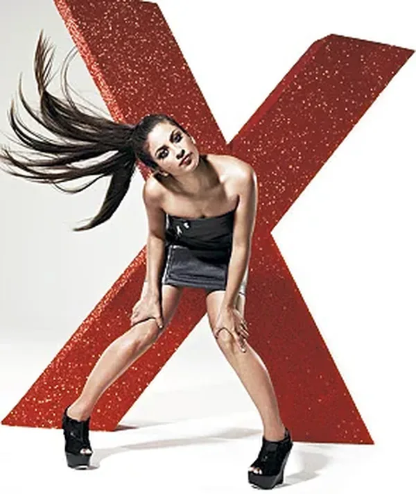 Model posing with an oversized red glitter X letter