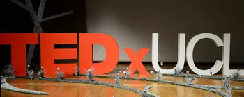 Freestanding red and white TEDx UCL letters on a stage