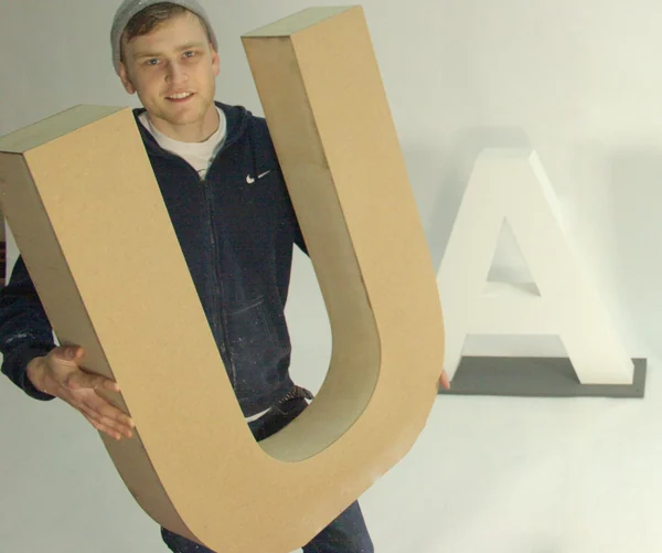 Stacked wooden 3D letters in different thicknesses and painted finishes