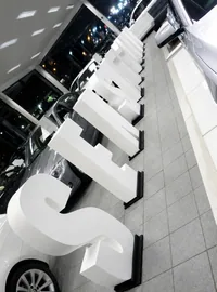 Large white display letters beside a car in a BMW showroom