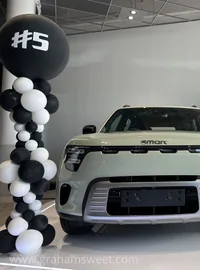 Large hashtag display letters beside a car in a showroom