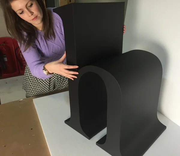 Woman inspecting a large black retail display letter