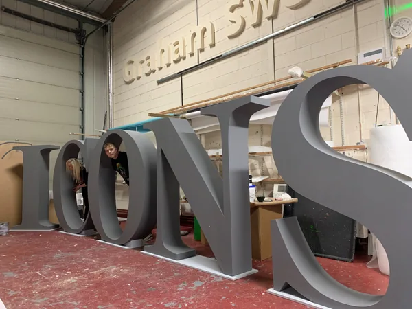 Large grey ICONS retail display letters in the workshop
