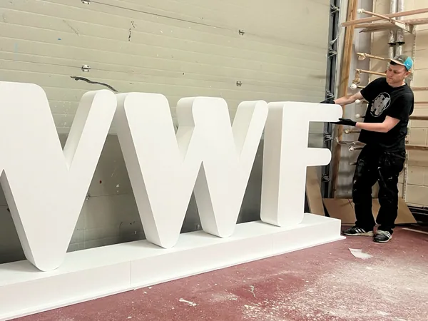 Large white WWF display letters with a workshop team member