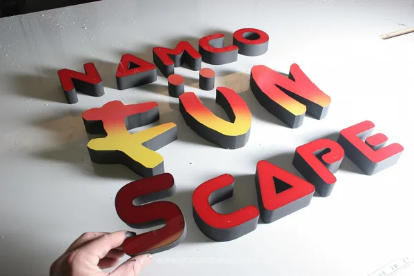 Red, yellow and black Namco logo letters during manufacture