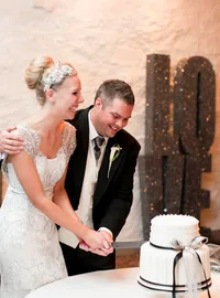 Bride and groom cutting their cake beside stacked LOVE letters