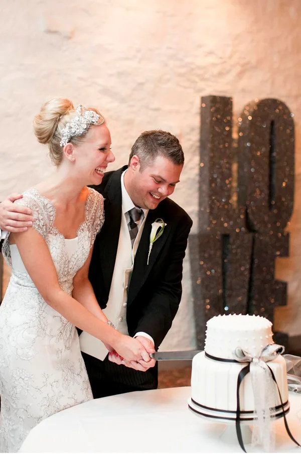 Bride and groom cutting their cake beside stacked glitter LOVE letters