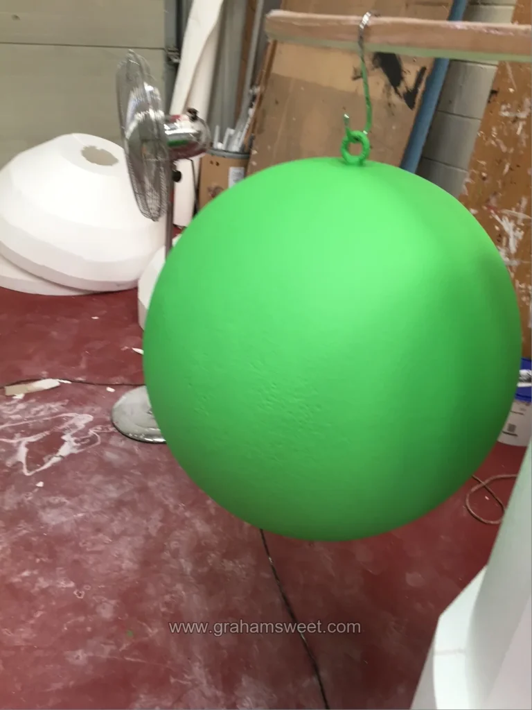 Large green painted polystyrene ball fitted with a secure hanging point