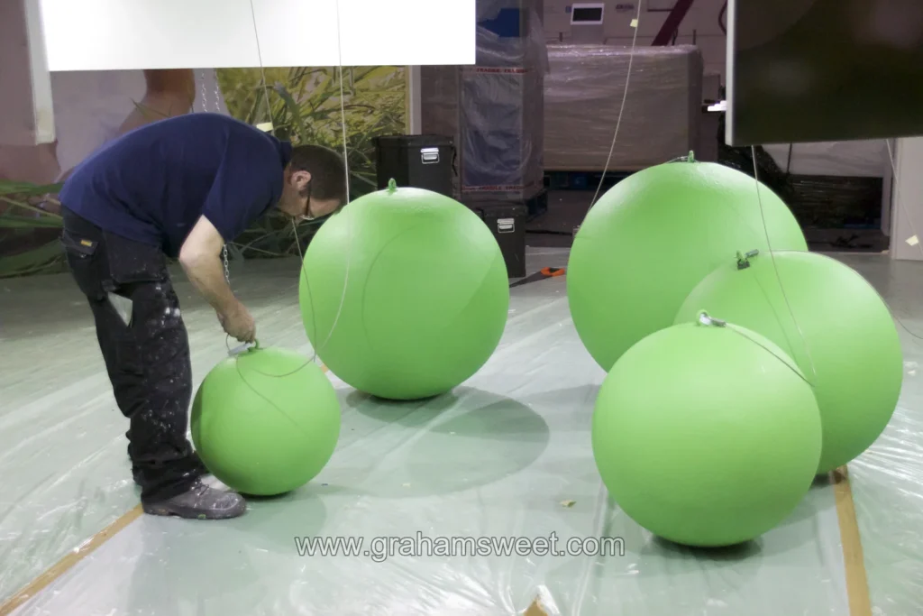 Green polystyrene balls with secure hanging points during exhibition stand installation