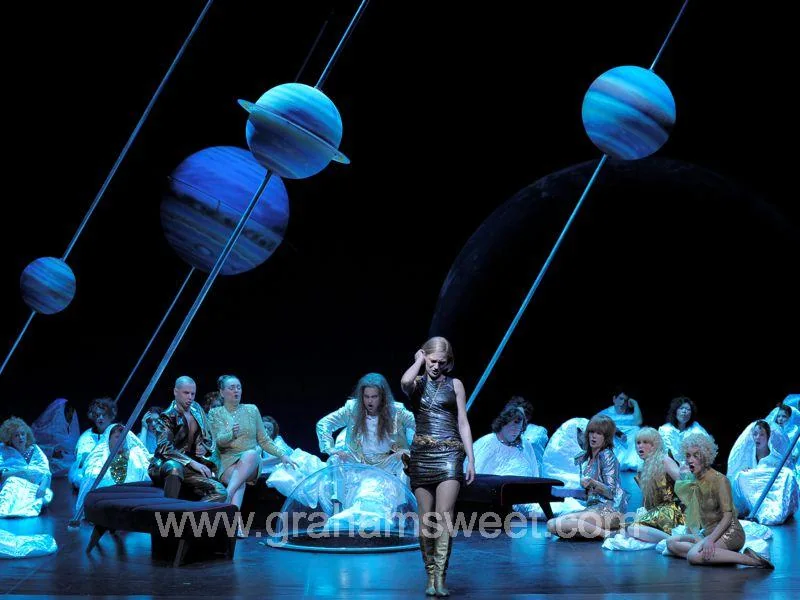 Giant painted planets suspended above performers on the Theater Koblenz stage
