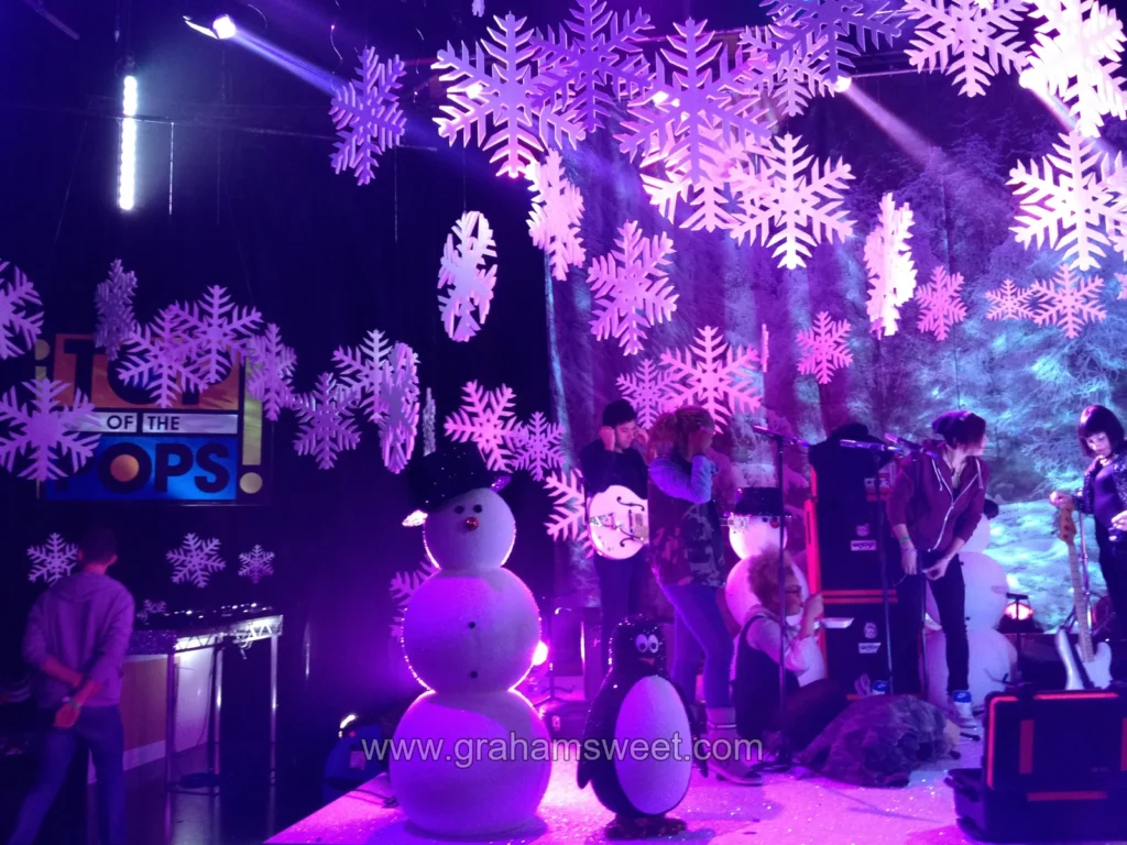 Hanging snowflakes lit in purple on the Top of the Pops stage