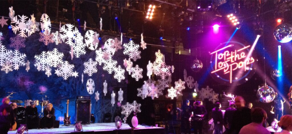 Hanging snowflake decorations surrounding a Christmas party stage