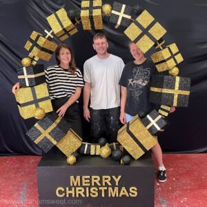 Staff standing inside an oversized Christmas Present Ring photo prop