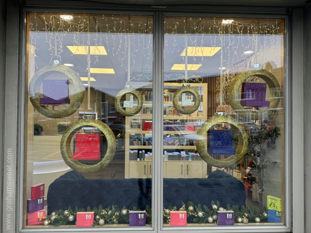 Salon window decorated with oversized bauble-shaped product display shelves