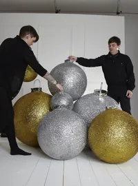 Large gold and silver Christmas baubles in a studio