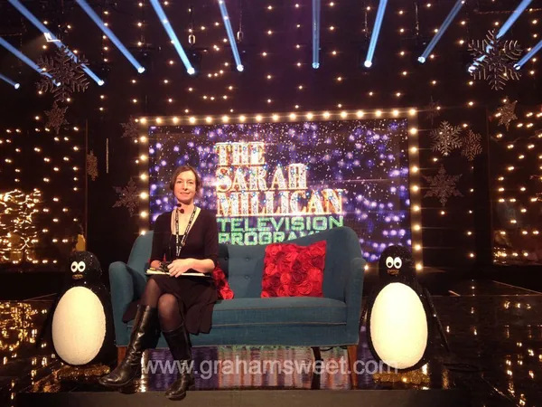 Christmas television set with presenter, penguins and festive props