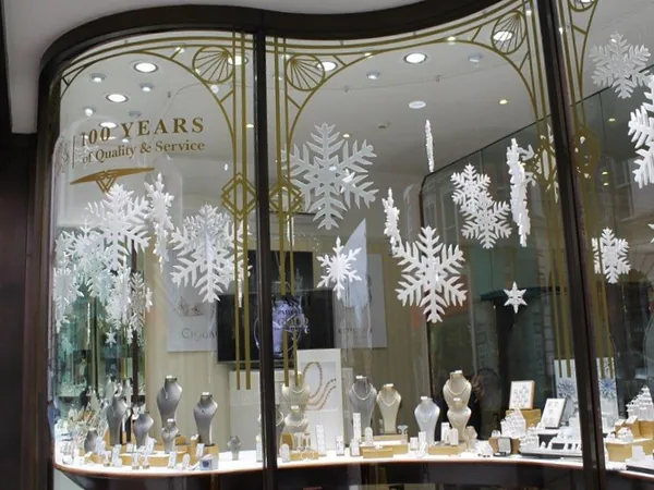 Christmas retail window decorated with hanging snowflakes