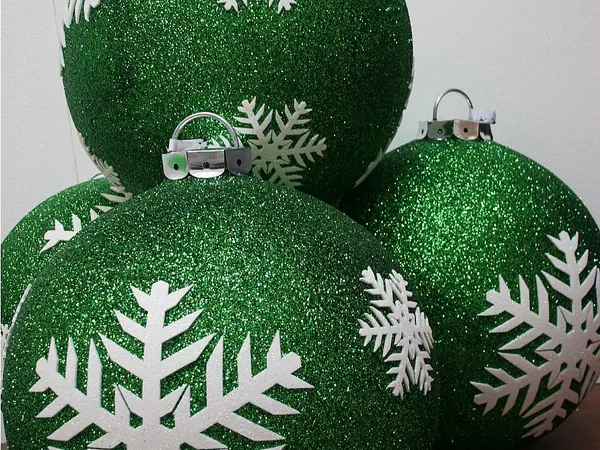 Green glitter baubles decorated with white snowflakes