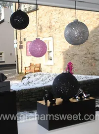 Pink and gunmetal glitter baubles in a shop