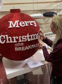 Branded red glitter bauble for a production