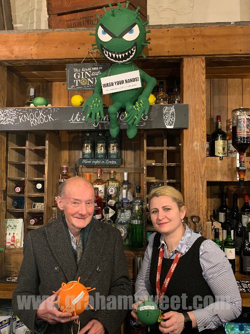 Large green model flu bug, suspended above the bar in a pub.