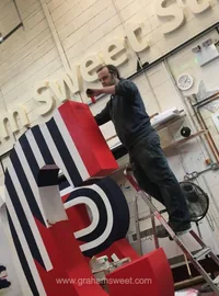 Large dimensional logo being installed on a wall