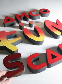 Painted bespoke letters arranged on the workshop floor