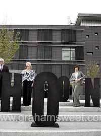 People standing beside large black outdoor letters