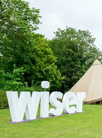 Large white Wiser letters at an outdoor festival